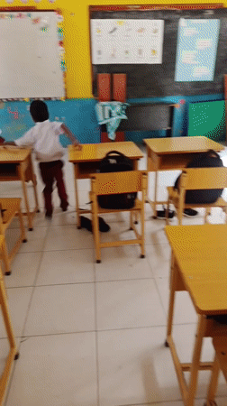 Boys play on classroom desks in Simpangjaya school
