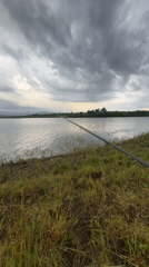 Angler fishes at lake under overcast skies in Bulgaria