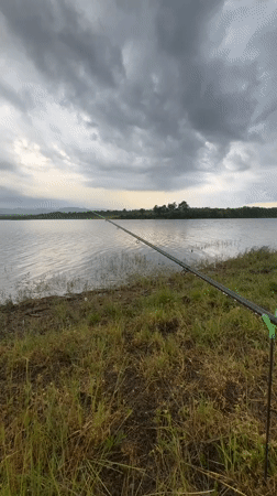 Angler fishes at lake under overcast skies in Bulgaria