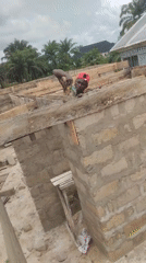 Construction worker hammers formwork beams in Agbarha Otor, Nigeria