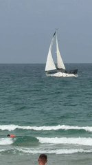 Overcast morning captured along Herzliya beach with sailboat offshore