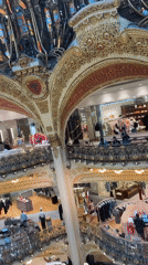 Morning shoppers browse multi-level Paris department store