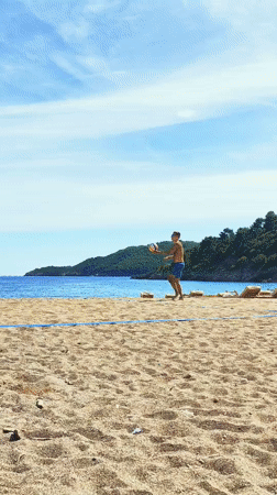 Men play beach volleyball on sunny Montenegro coast