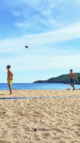 Men play beach volleyball on sunny Montenegro coast