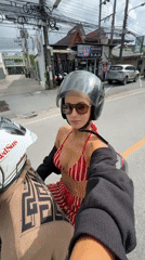 Couple rides motorcycle near beach in Rawai, Thailand