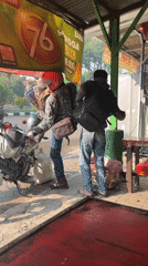 Busy morning motorcycle traffic through Candi, Indonesia at sunrise
