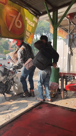 Busy morning motorcycle traffic through Candi, Indonesia at sunrise