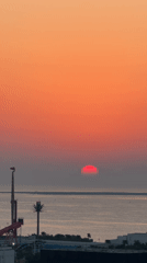Hazy red sunset over an urban waterfront