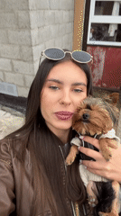 Woman poses with dog, then prepares wood splitting in Russia