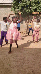 Kids dance and play drums together in a village setting