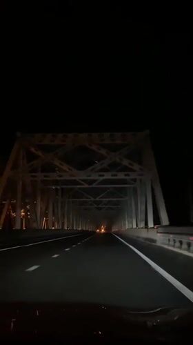 Night drive through rural Russia, bridge crossing in the rain