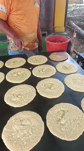 Street vendor cooks flatbreads on griddle in Tinaquillo