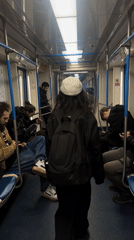 Passenger in white hat rides Moscow subway train