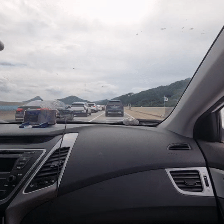 Highway traffic jam in Jinbu-myeon under cloudy mountain skies