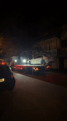 White sedan towed at night in Tbilisi, Georgia