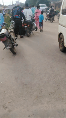 Street scene captured in Ikorodu showing people, motorcycles, van