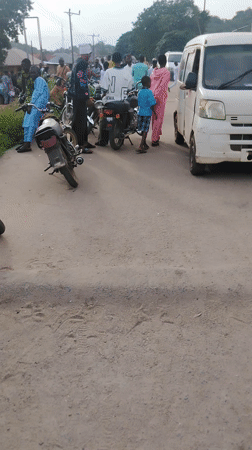 Street scene captured in Ikorodu showing people, motorcycles, van