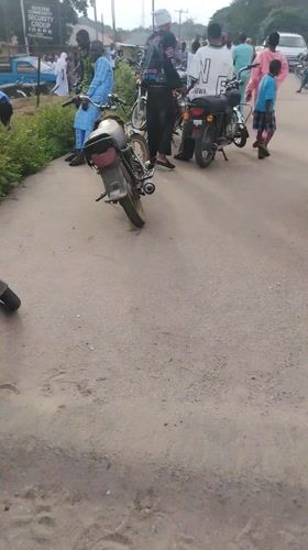 Street scene captured in Ikorodu showing people, motorcycles, van