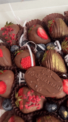 Person samples decorated chocolate strawberries in Birobidzhan gift box