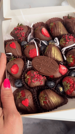 Person samples decorated chocolate strawberries in Birobidzhan gift box