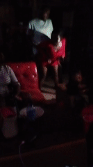 Woman dances in red dress at indoor gathering