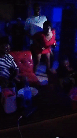 Woman dances in red dress at indoor gathering