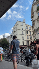 Man walks past parked vehicles on Paris street