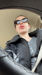 Woman makes playful tongue gesture at camera in Moscow car