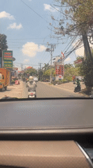 Dashcam view of motorcycle-heavy traffic through Mengwi streets