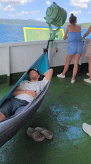 Man sleeps in hammock on boat deck near Gerung