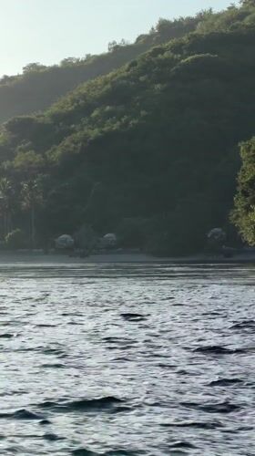 Choppy waters captured near tree-lined beach in Nusa Penida