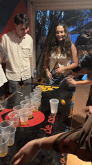 Young adults play beer pong at São Paulo venue