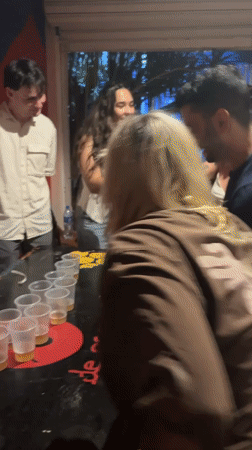 Young adults play beer pong at São Paulo venue