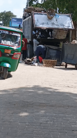 Waste workers collect garbage on Dar es Salaam street
