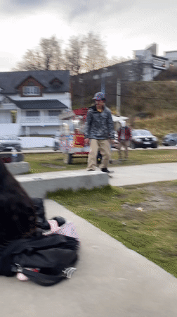 Skateboarder practices tricks on concrete steps in Ushuaia park