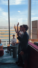 Indoor gathering in London with people mingling and speaking on mic