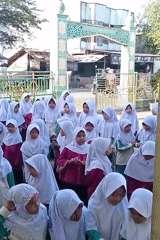 Students gather in Indonesian schoolyard amid blooming desert flowers