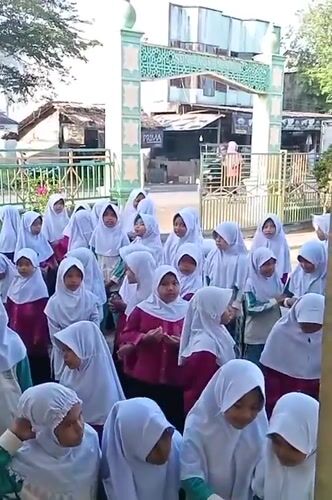 Students gather in Indonesian schoolyard amid blooming desert flowers