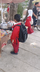 Street activity near parked scooters and market stalls in Krian