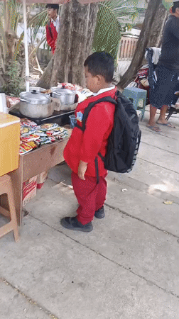 Street activity near parked scooters and market stalls in Krian