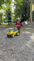 Child plays with yellow toy car in Erba