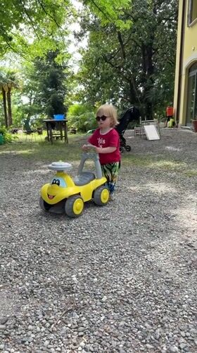 Child plays with yellow toy car in Erba