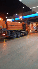 Service trucks conduct nighttime road work in Moscow