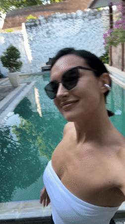 Woman films selfie videos while dancing poolside in North Kuta