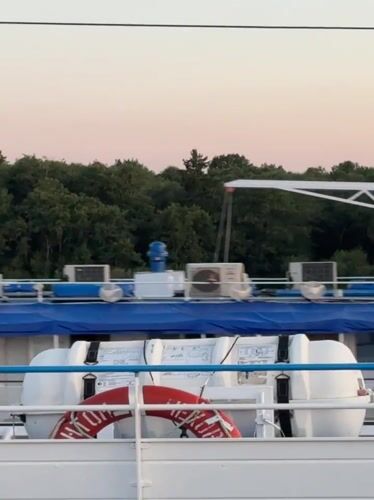 Cruise ship passes Lapach at sunset on the Russian waterway