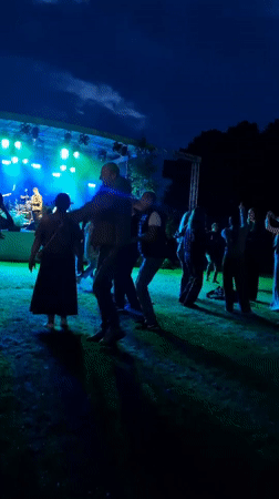 Outdoor concert night in Priekule, Latvia — band plays, crowd dances
