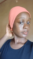 Woman in pink headscarf poses for camera