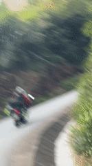 Motorcyclists travel mountain road in rural Vietnam commune