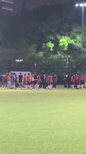 Soccer players gather on Shanghai field at night