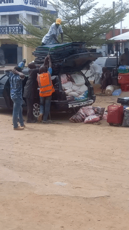 Travelers load vehicles with belongings in Dadi Riba, Nigeria